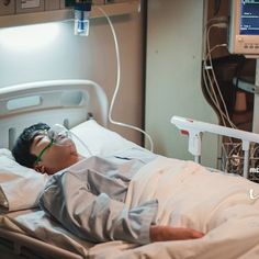 a man laying in a hospital bed wearing goggles