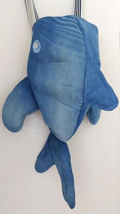 a blue stuffed fish hanging on the wall