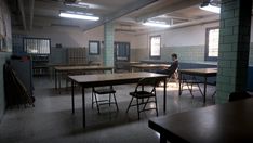 an empty classroom with desks and chairs in front of the boys sitting at their desks