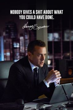 a man in a suit sitting at a table with a laptop