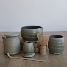 a group of ceramic items sitting on top of a wooden table