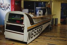 a food cart sitting on top of a hard wood floor next to a counter filled with drinks