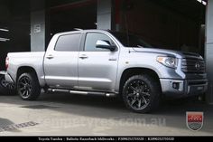 a silver truck parked in front of a garage