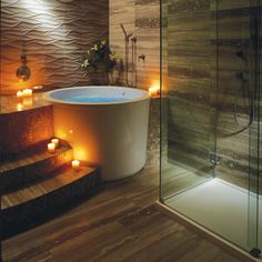 a bathroom with candles on the floor and a bathtub in the middle of it