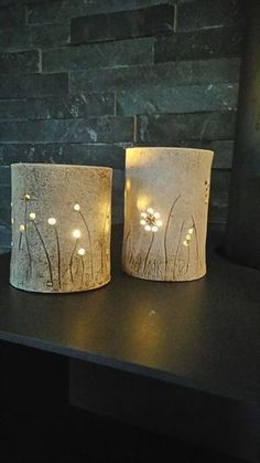 two lamps with flowers on them sitting on a table