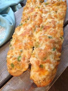 a cheesy bread is sitting on a wooden table