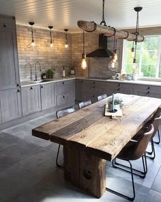 a large wooden table sitting in the middle of a kitchen