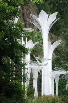 a white sculpture in the middle of some trees