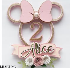 a pink and gold minnie mouse birthday cake topper with the number two on it