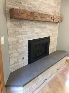 a fireplace with a stone mantle and wooden mantel