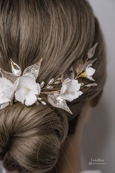 a woman wearing a white flower and leaf headpiece with hair pins in her hair