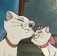 two cats are kissing each other in front of a mirror