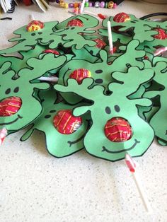 green paper cutouts with candy sticks sticking out of them