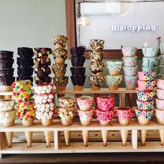 a table topped with lots of different types of candy cones and cups filled with candies