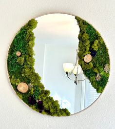 a mirror that has moss growing on it and some lights in front of the mirror