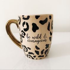 a coffee cup with black and white animal print on the inside that says, be wild & courageous