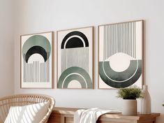 three framed art pieces hang on the wall above a wooden bench in a white room