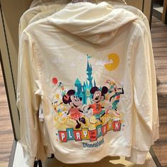 Brand New Hooded Sweatjacket Full Zip Front Embroidered And Screen Art On Back Features Mickey, Minnie, Goofy And Pluto, Plus Sleeping Beauty Castle Art, Disneyland And ''Play In The Park'' Logos Embroidered Minnie Mouse With Balloon Appliqu On Chest, Plus Sleeping Beauty Castle Screen Art Soft Knit Fabric Long Sleeves Lined Hood With Drawstring Closure Ribbed Hem And Cuffs French Terry Interior Part Of The Play In The Park Collection The Bare Necessities Body: 80% Cotton / 20% Polyester Rib: 95 White Disney Sweatshirt For Fall, Cotton Hoodie For Disney Fan Events, Cotton Hooded Hoodie For Disney Fan Events, Casual Hooded Sweatshirt For Disney Fan Events, Mickey Mouse Long Sleeve Fleece Hoodie, Mickey Mouse Fleece Hoodie, Mickey Mouse Fleece Hoodie With Long Sleeves, Disney Hoodie For Fall, Disney Hoodie With Long Sleeves For Fall