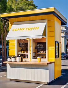 a small yellow and white coffee shop sitting on the side of a road