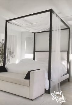 a white bed sitting in the middle of a bedroom