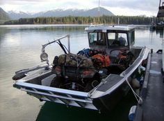 a small boat is docked at the dock with gear on it's front end