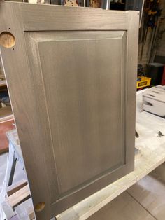 an unfinished cabinet door is shown in the process of being painted and polished with silver paint