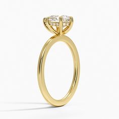 a yellow gold engagement ring with an oval cut diamond on the center and side stones