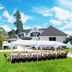 an outdoor party with tables and chairs set up in front of a large white house