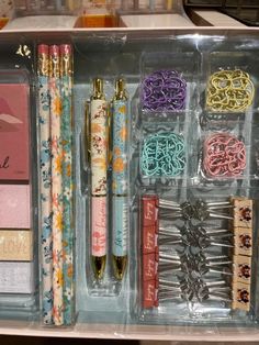 an organized drawer with pens, scissors and other items in it on display at a store