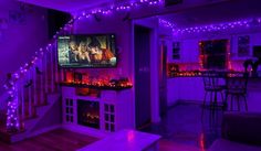 a living room with purple lights and a tv on the wall in front of it