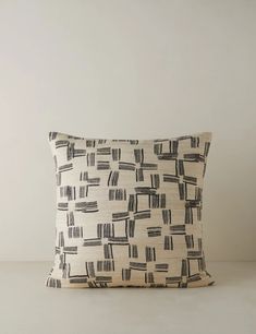 a black and white pillow sitting on top of a table