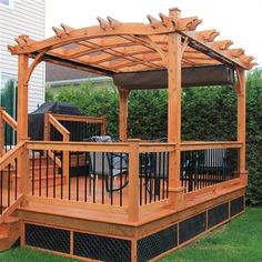 a wooden gazebo sitting on top of a lush green field