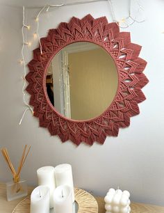 a mirror on the wall above a table with candles