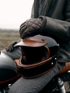 a person wearing a leather jacket and gloves on a motorcycle