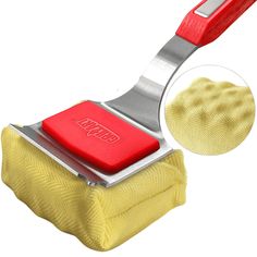 a yellow sponge with a red handle on it