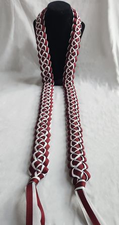 a red and white neck tie on top of a black mannequin headdress