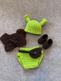 a crocheted hat, diaper and booties are laying on the floor