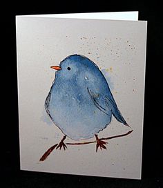 a blue bird sitting on top of a white card