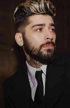 a man in a suit and tie looking off to the side