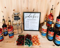 there are many different types of liquors on the table and in front of it is a sign