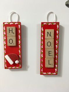 two wooden scrabbles with letters spelling noel and santa hat hanging from hooks