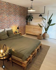 a bedroom with brick walls and wooden pallets on the floor, along with a large bed