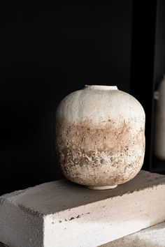 a white vase sitting on top of a cement block