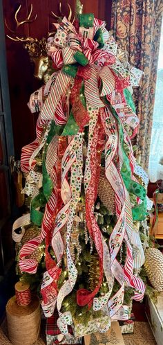 a christmas tree decorated with ribbons and bows