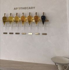 there are many bottles on the wall with nameplates in gold and black colors