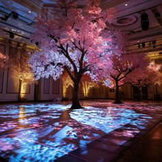 a tree that is sitting in the middle of a room with projected lights on it