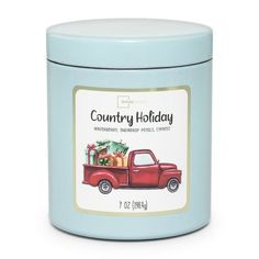 the country holiday tin candle is blue and has a red truck with presents on it