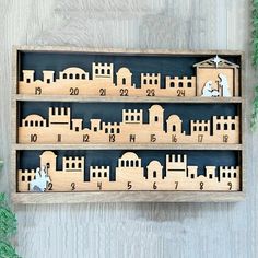 a wooden christmas ornament with nativity scene in the middle on a shelf