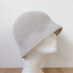 a white knitted hat sitting on top of a mannequin head