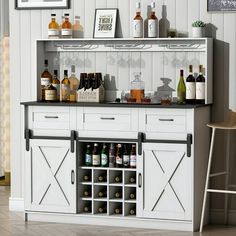 a white cabinet with bottles and glasses on it in a room next to a bar